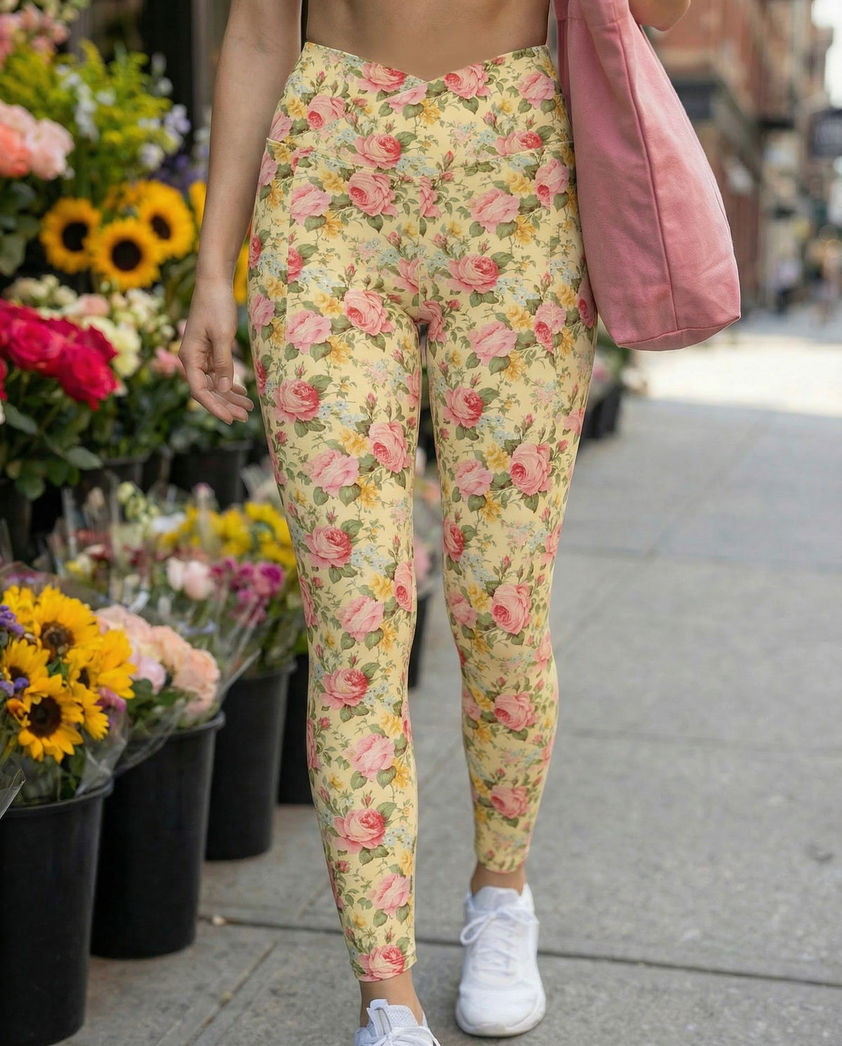 woman wearing crossover butter yellow leggings with side pockets with pink yellow and blue rose florals feminine botanical patterns showing the front