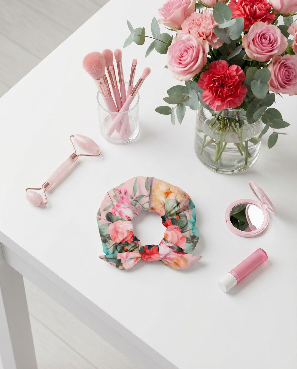 Baby pink scrunchie with feminine colorful botanical floral pattern on it with bow detail front view