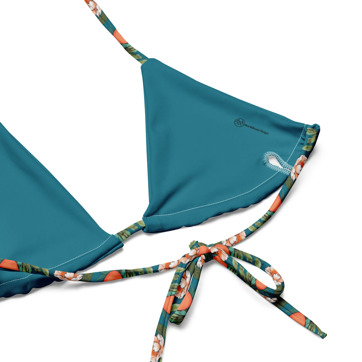 teal bikini with a peach and flower print on it showing close-up details of lining and adjustable ties