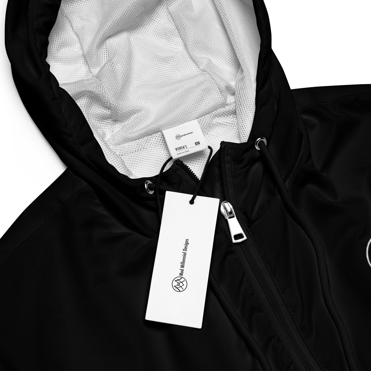 Close-up of black cropped windbreaker showing zipper, hood drawcords, and interior lining