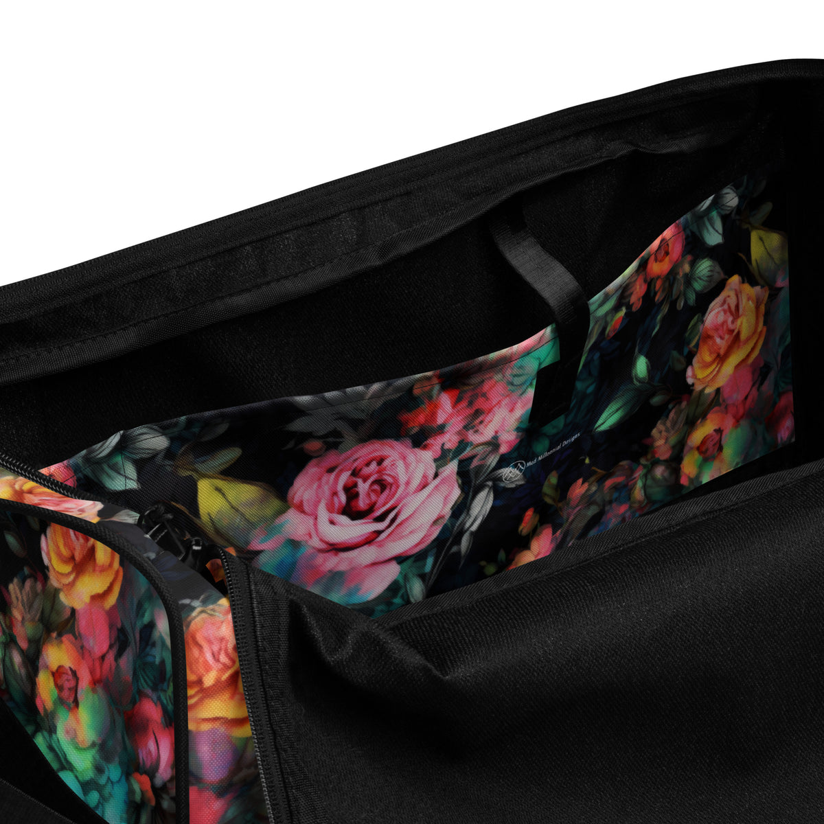 Full size black duffle bag with black handles and removable black shoulder strap and zipper enclosure with vivid rose feminine botanical floral pink yellow and teal pattern showing a close up of the inside pocket with the logo